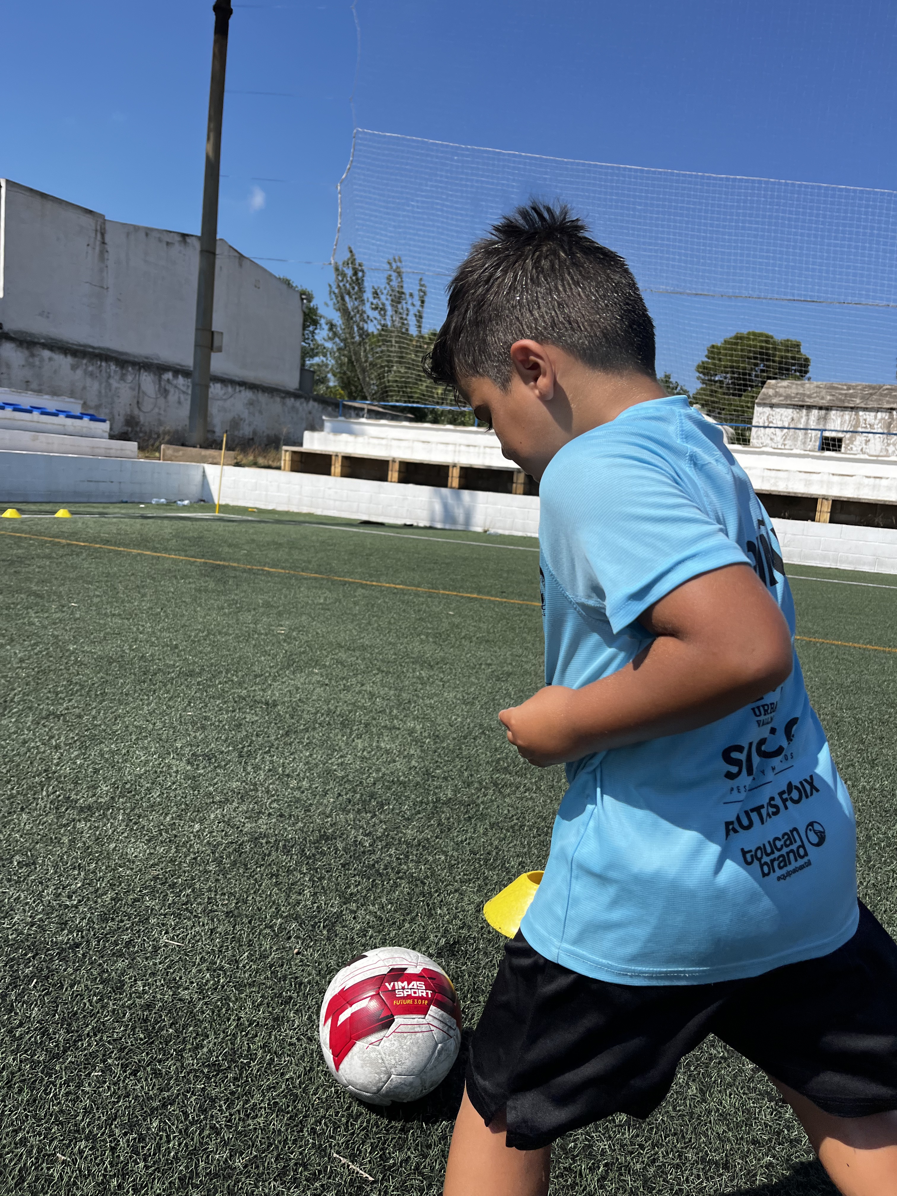 Participante conduciendo el balón en el Campus de verano 2025