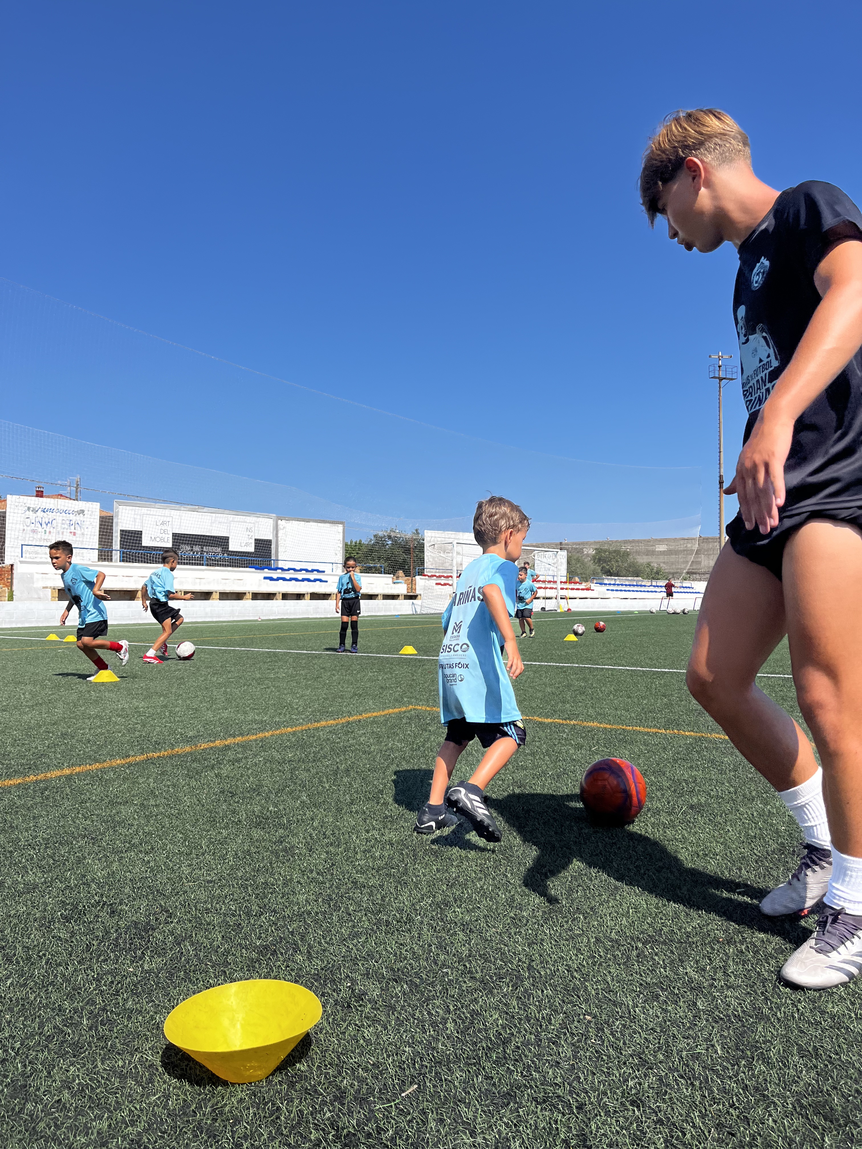 Entrenador acompañando un ejercicio de técnica en el Campus de verano 2025